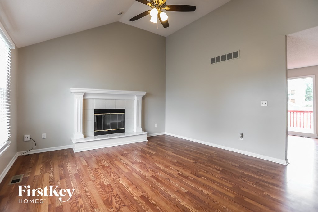 the living room with wood floors and a fireplace