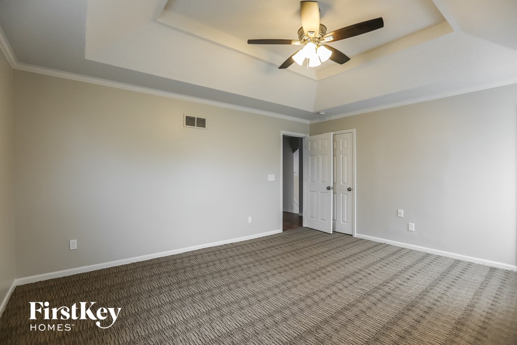 the living room of an empty house with a ceiling fan