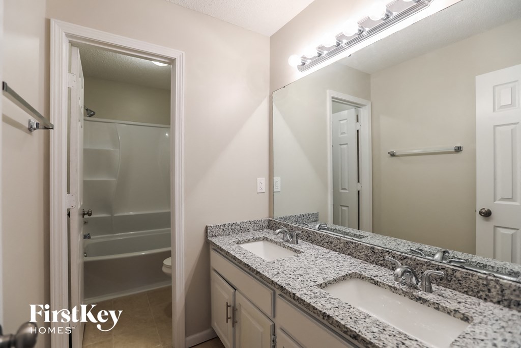 a bathroom with two sinks and a mirror and a shower