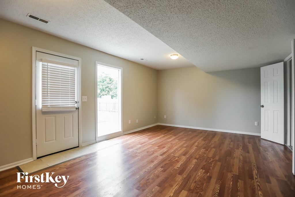 the spacious living room with hardwood flooring and white doors