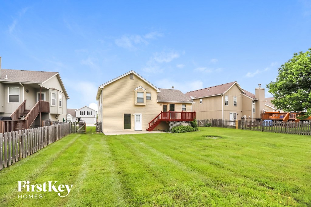 the backyard of a house with a yard and a red deck