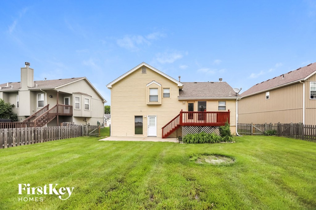 the backyard of a house with a yard and a red deck