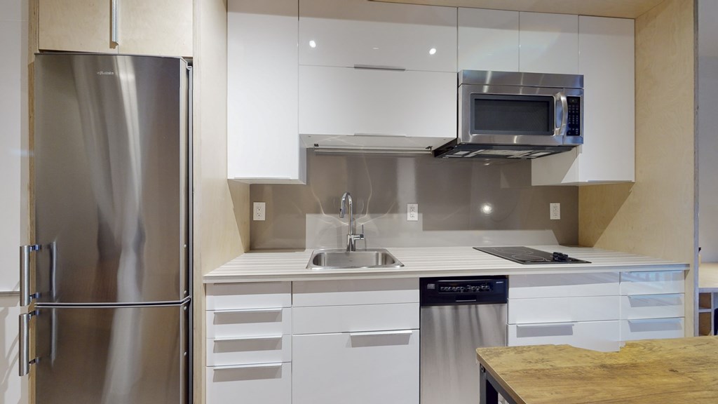a kitchen with white cabinets and a stainless steel refrigerator
