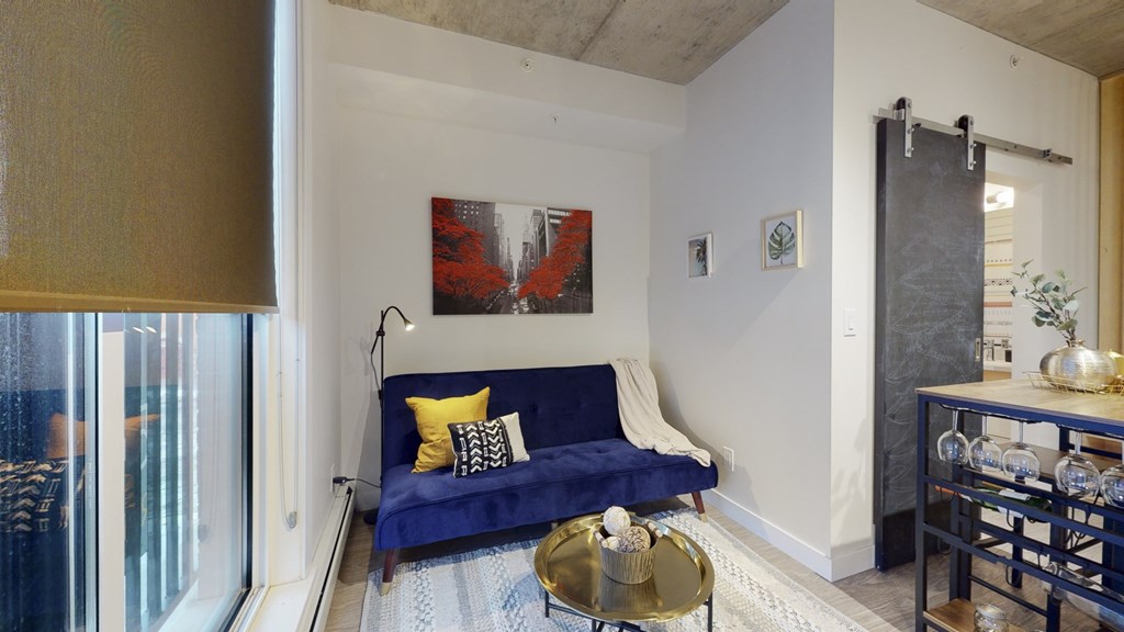 a living room with a blue couch and a window