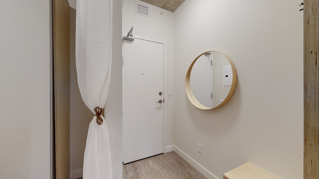 a bathroom with a mirror and a shower and a white door
