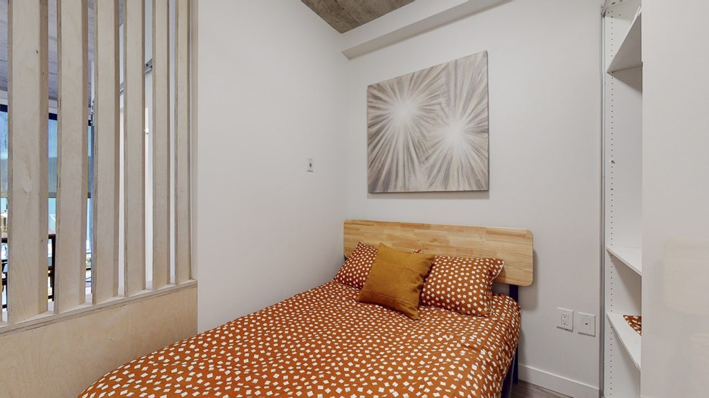 a bedroom with a bed and a painting on the wall