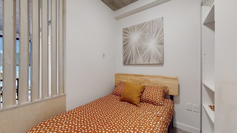 a bedroom with a bed and a painting on the wall
