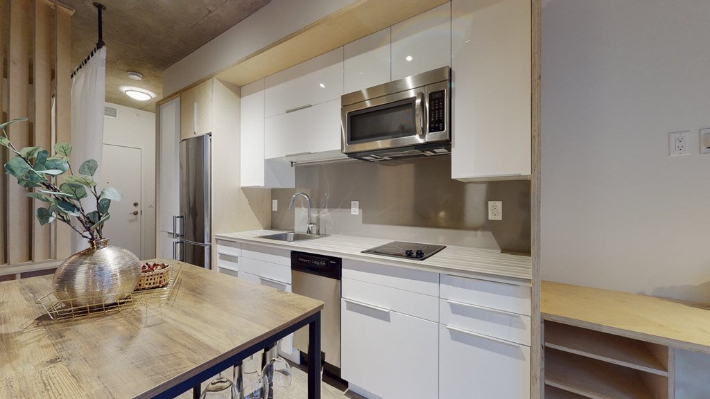 a kitchen with white cabinets and a wooden table