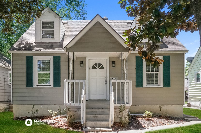 a small house with a white door and green shutters