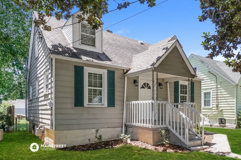 a white house with green shutters and a white porch