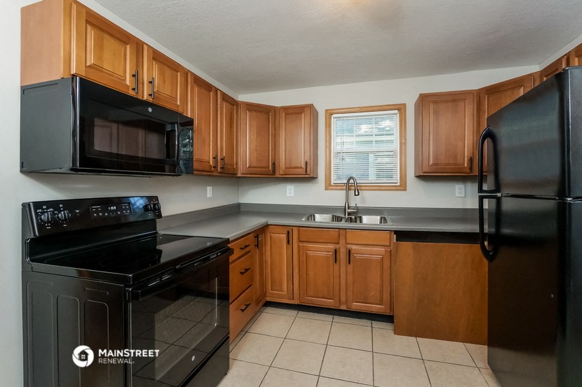 a kitchen with black appliances and wooden cabinets