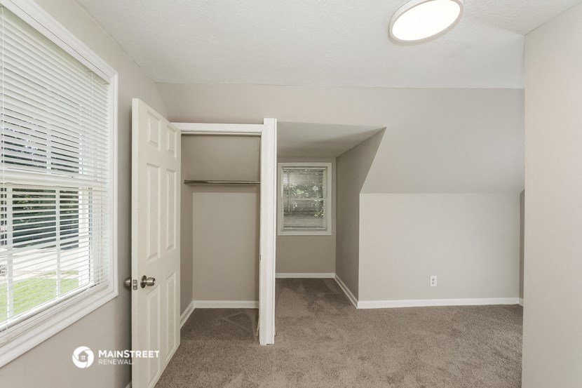 an empty bedroom with a closet and a window