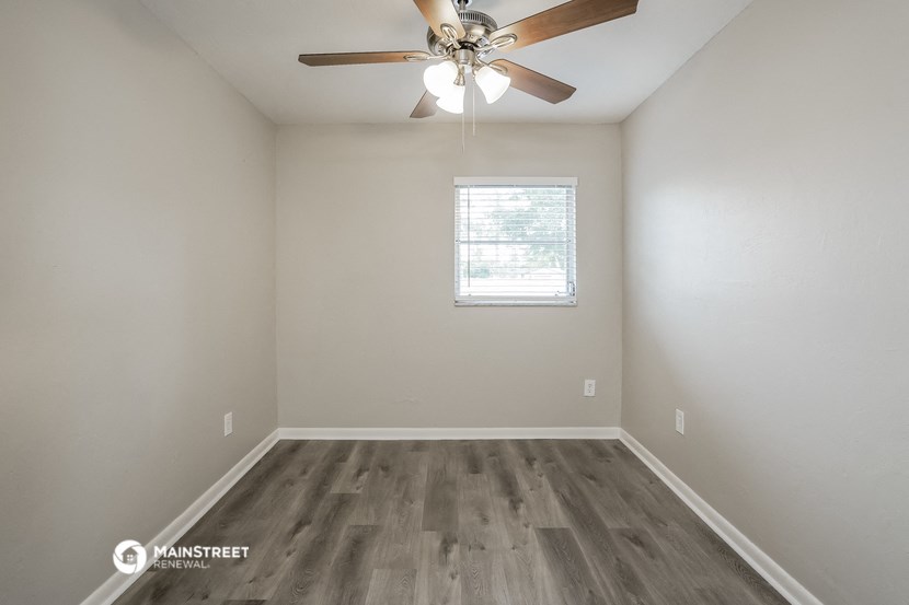 the bedroom of our studio apartment atrium with wood flooring and ceiling fan