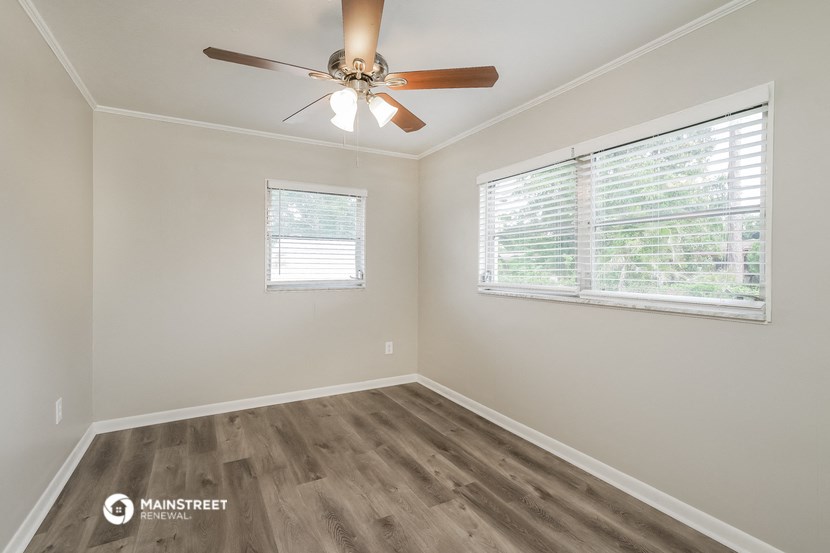 a bedroom with a ceiling fan and a window