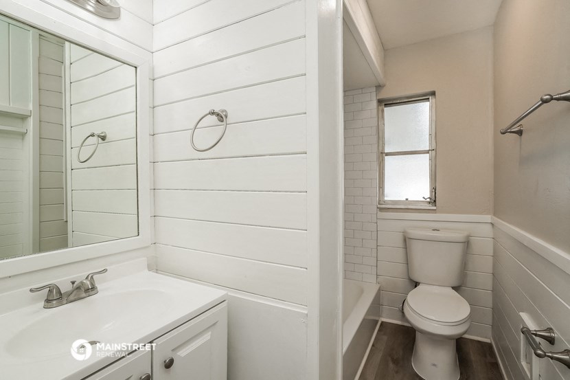 a bathroom with a toilet and a sink and a mirror