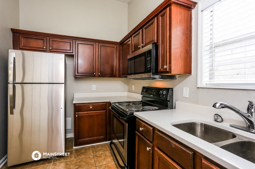 a kitchen with wooden cabinets and a sink and a refrigerator