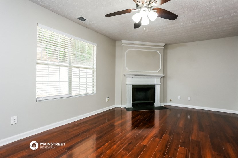 the living room of a house with wood floors and a fireplace