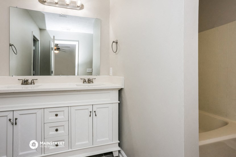 a bathroom with a sink and a mirror and a tub