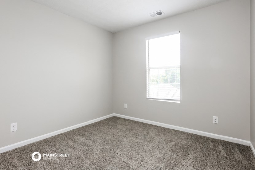an empty room with carpet and a window