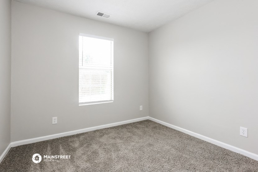 an empty room with carpet and a window