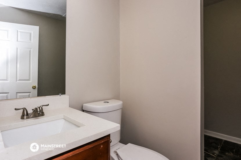 a bathroom with a toilet and a sink and a mirror