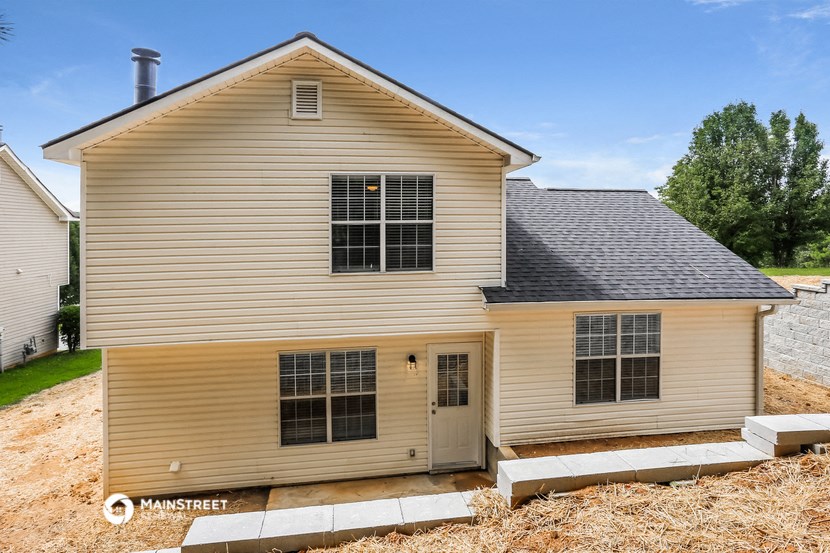 side view of a house with a garage and a gravel driveway