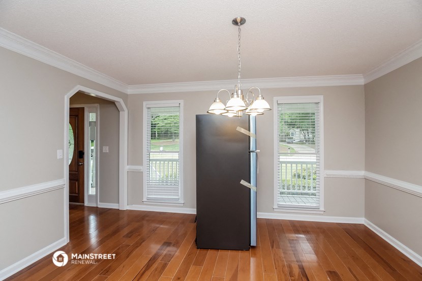 an empty dining room with a refrigerator in the middle of it