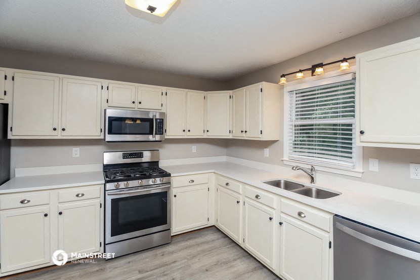 a kitchen with white cabinets and stainless steel appliances