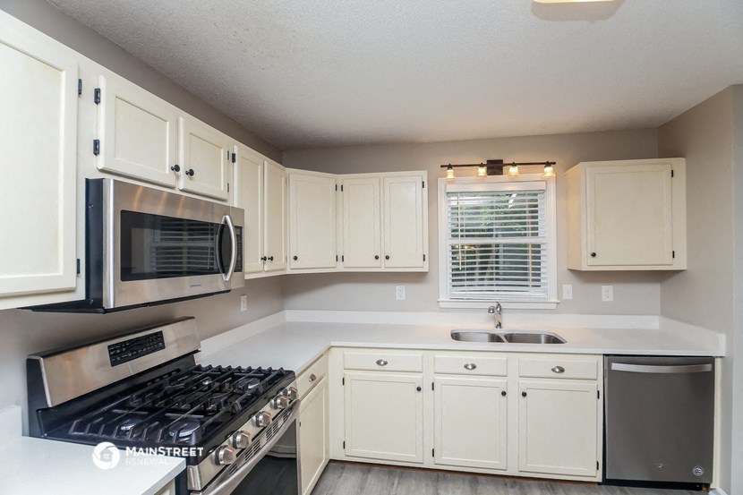 a kitchen with white cabinets and a stove and a microwave