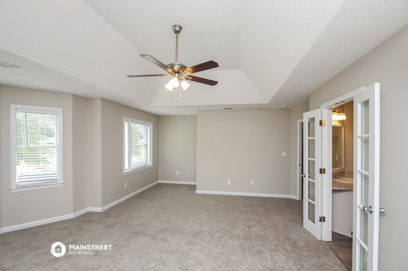 the living room of an empty house with a ceiling fan