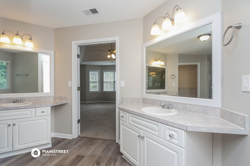 a white bathroom with a large mirror and a sink
