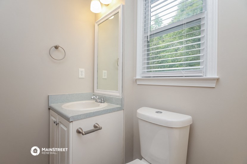 a small bathroom with a toilet and a sink and a window