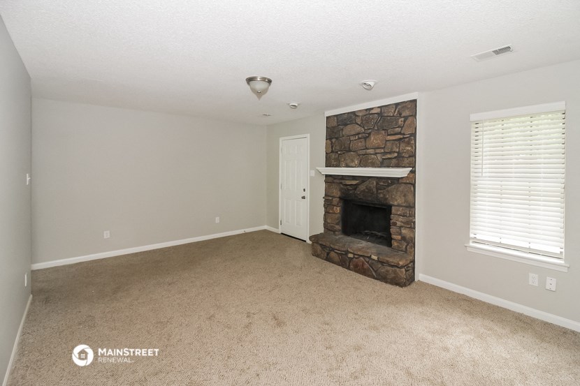 a living room with a fireplace and a carpeted floor