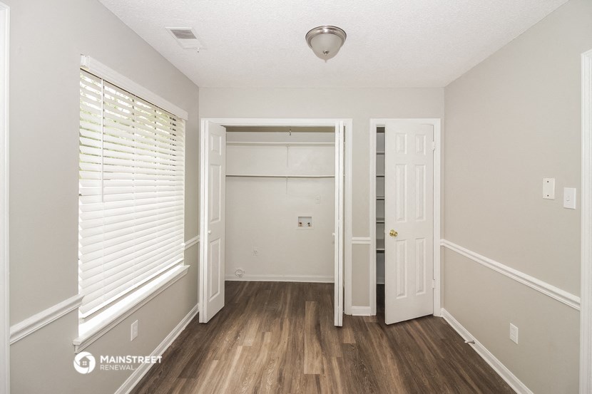 a bedroom with a closet and a door to the bathroom