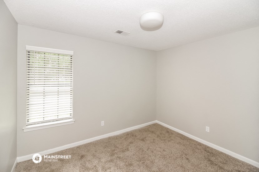 an empty room with carpet and a window