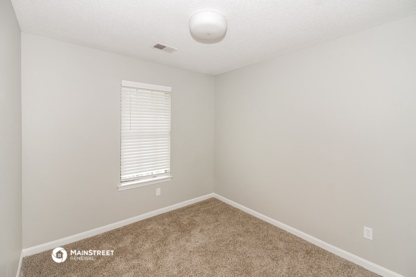 an empty room with carpet and a window