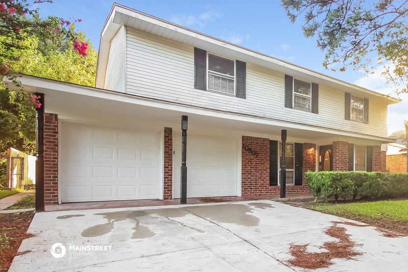 a white and brick house with a white garage door