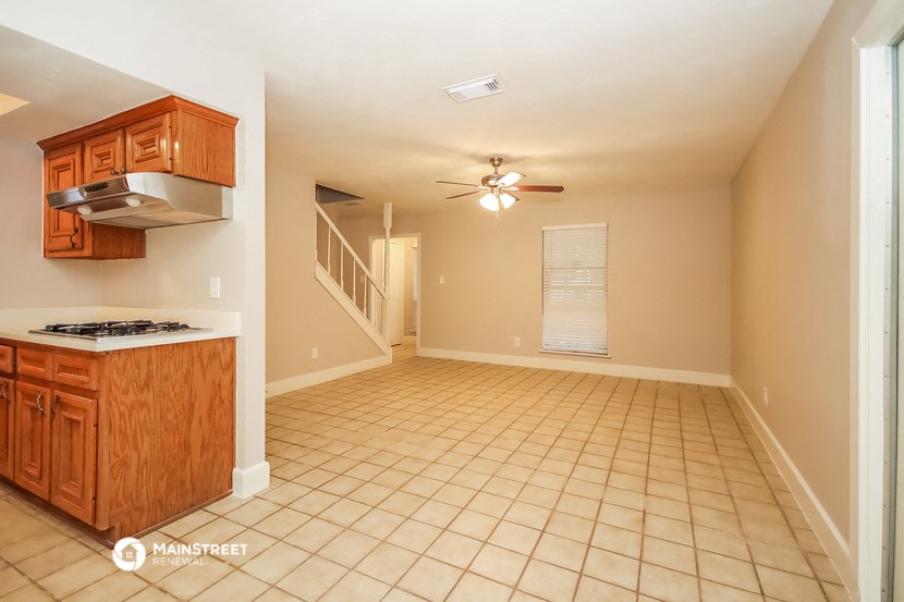 an empty kitchen and living room with a ceiling fan