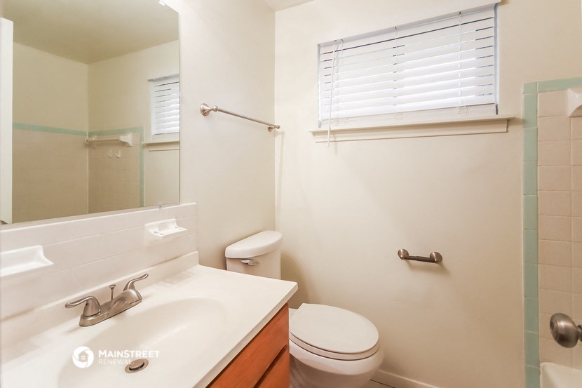 a bathroom with a toilet and a sink and a mirror