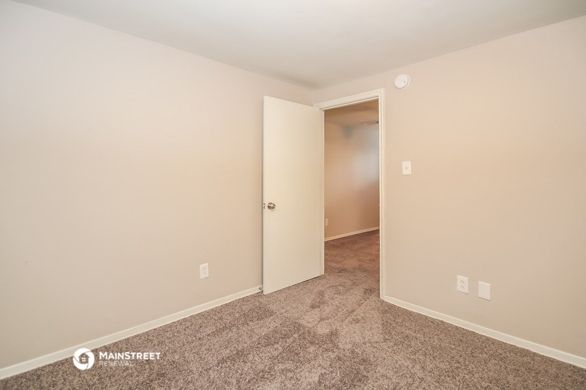 a bedroom with carpet and a door to a closet