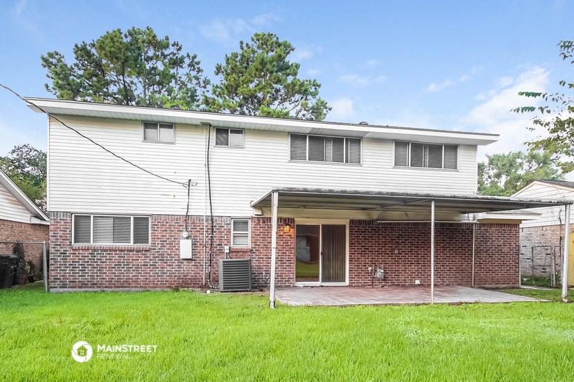a white and brick house with a yard in front of it