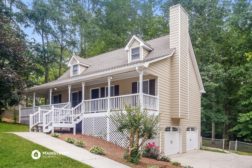 a tan house with a porch and a white deck