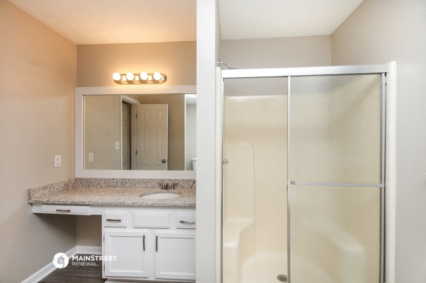 a bathroom with a sink and a shower and a mirror