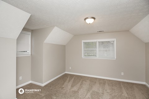 the spacious living room of a manufactured home with carpet and a window
