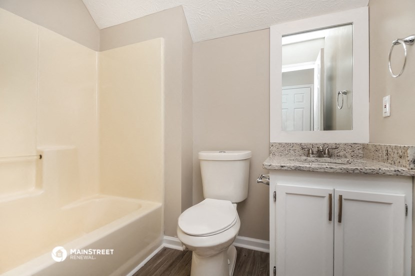 a bathroom with a toilet and a sink and a bath tub