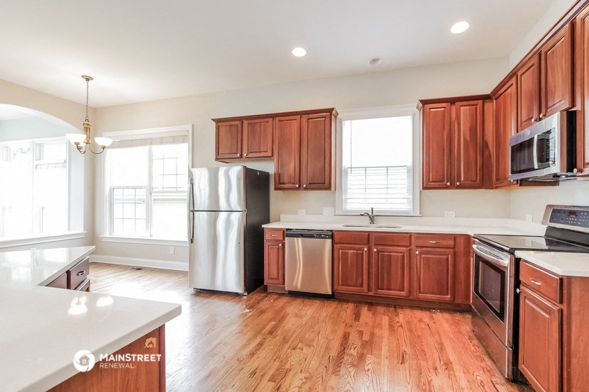 an empty kitchen with wooden cabinets and stainless steel appliances
