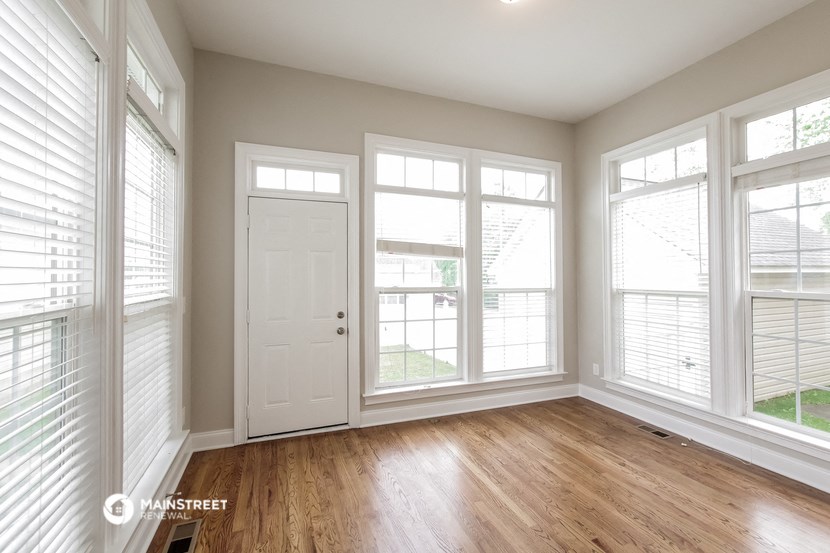 the living room of a new home with wood floors and large windows