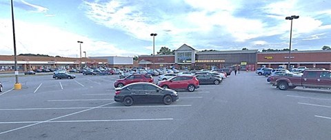 a parking lot filled with cars in front of a store