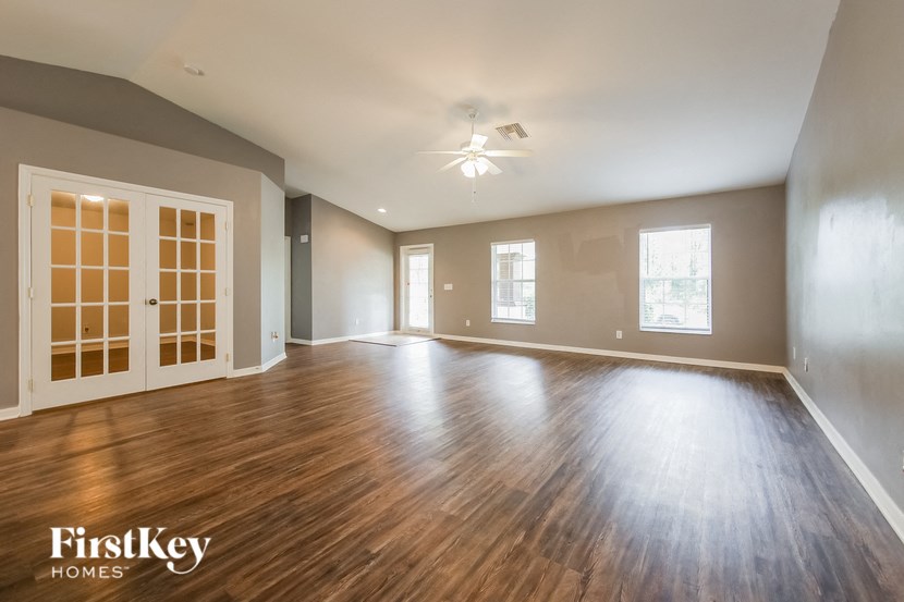 an empty living room with wood flooring and a white door