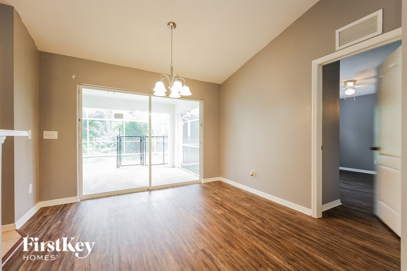 an empty living room with wood flooring and a large window